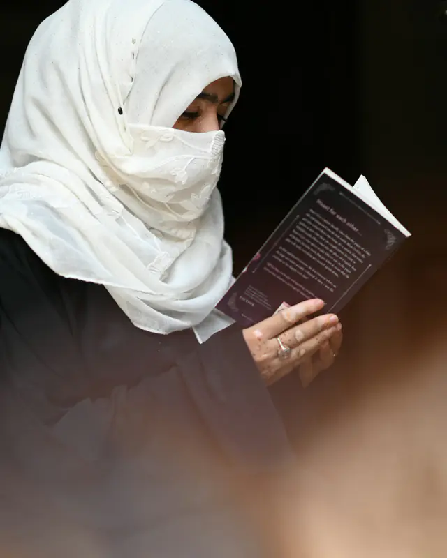 Muslim woman in a white hijab reading, representing guidance from a female Islamic scholar